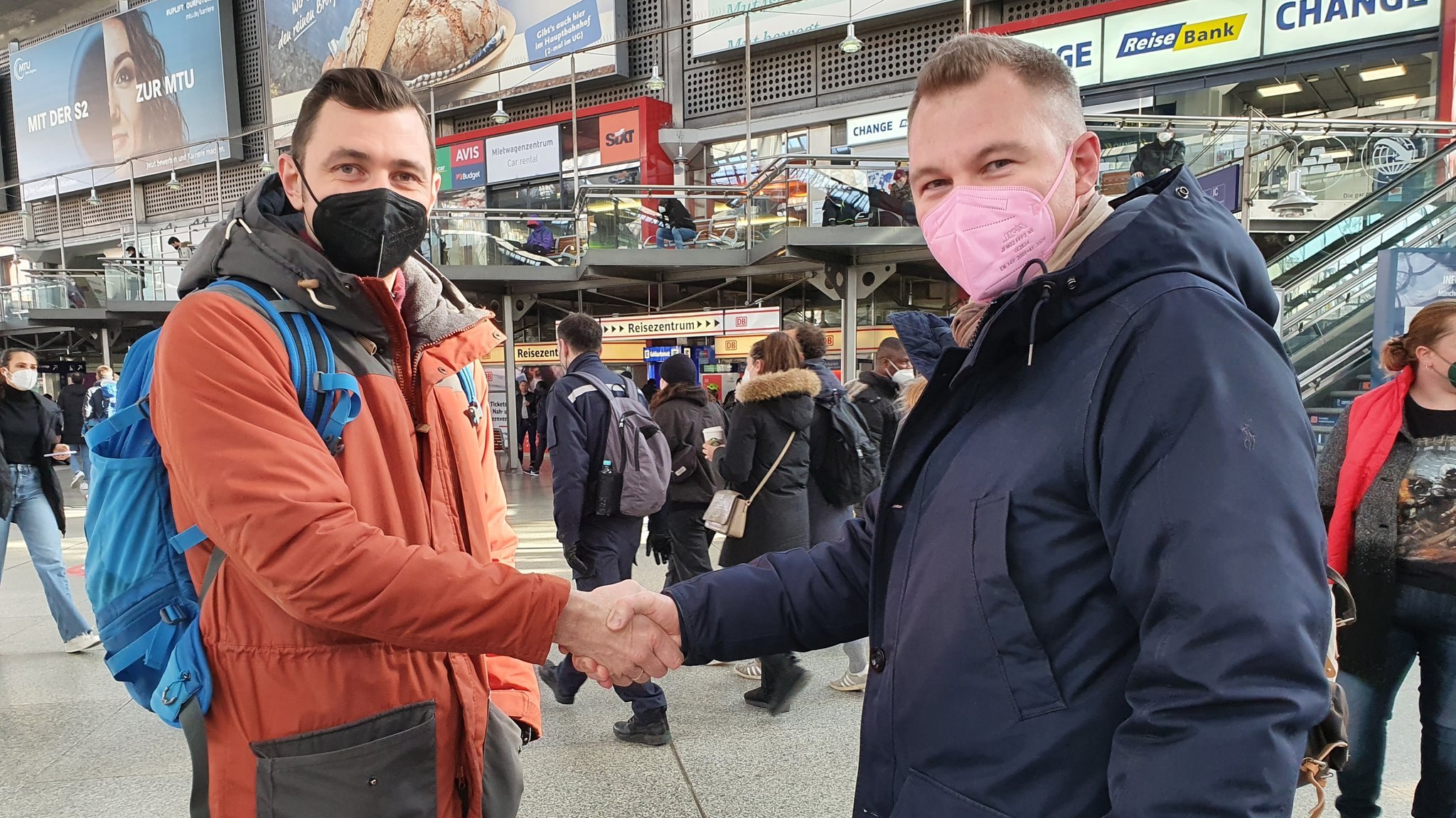 Helfer aus der Ukraine (links) und aus Russland (rechts) am Hauptbahnhof München.