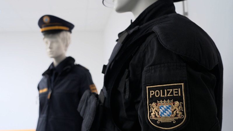 Zwei Kleiderpuppen tragen Uniformen mit dem weiß-blauen Rautenwappen des Freistaats Bayern.