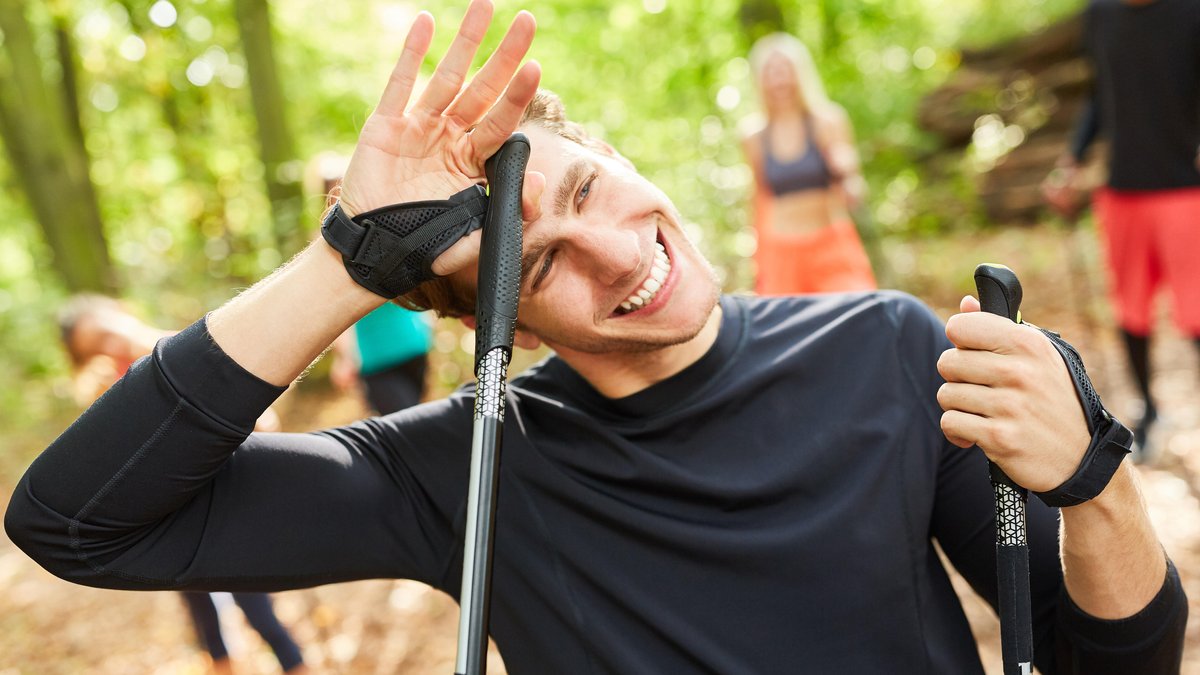 Schwitzender Fitness-Trainer beim Nordic Walking für Gesundheit und Ausdauer