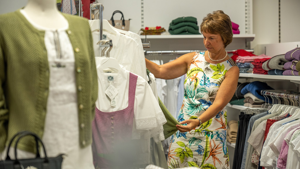 Eine Frau betrachtet ein Kleidungsstück in der Modeabteilung.