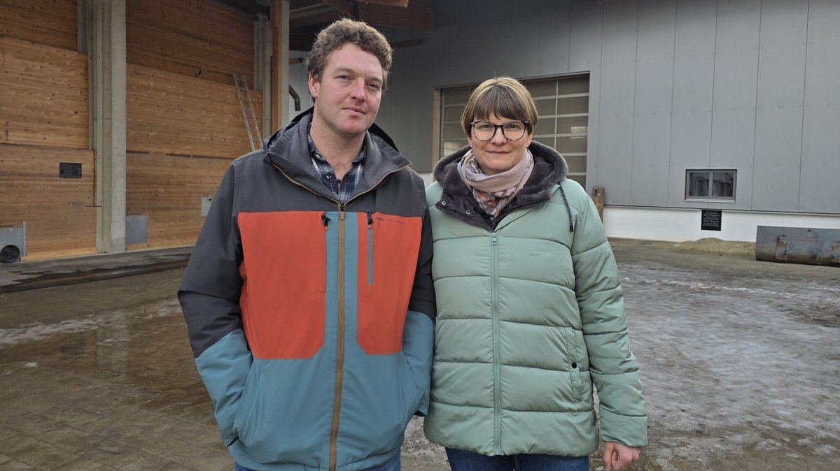 Die Zieglmeiers stehen im Innenhof vor ihren Hopfen- und Getreidehallen.