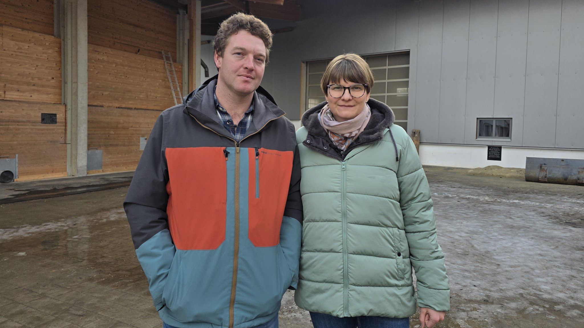 Die Zieglmeiers stehen im Innenhof vor ihren Hopfen- und Getreidehallen.