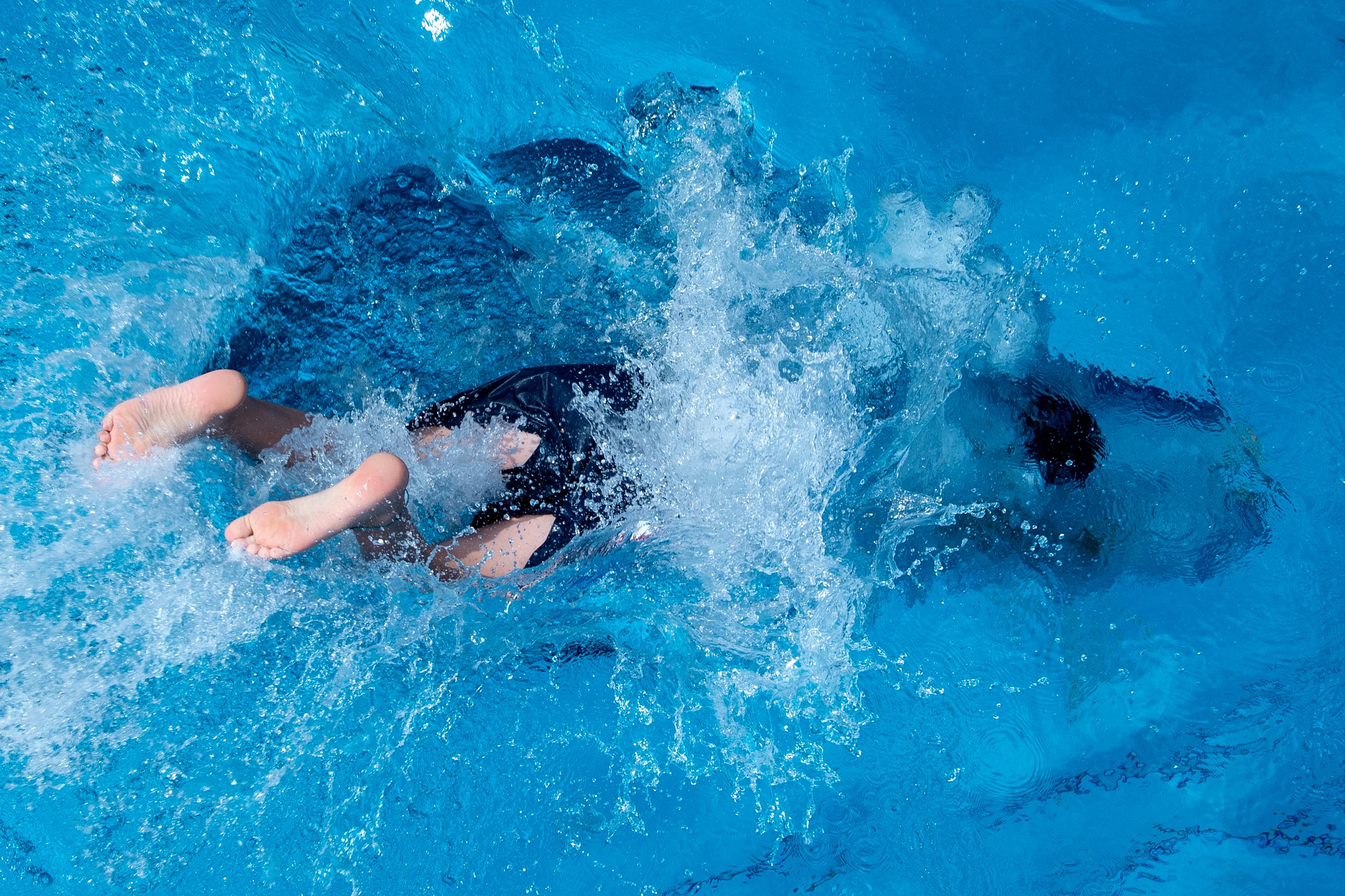 Jemand taucht im Freibad ab