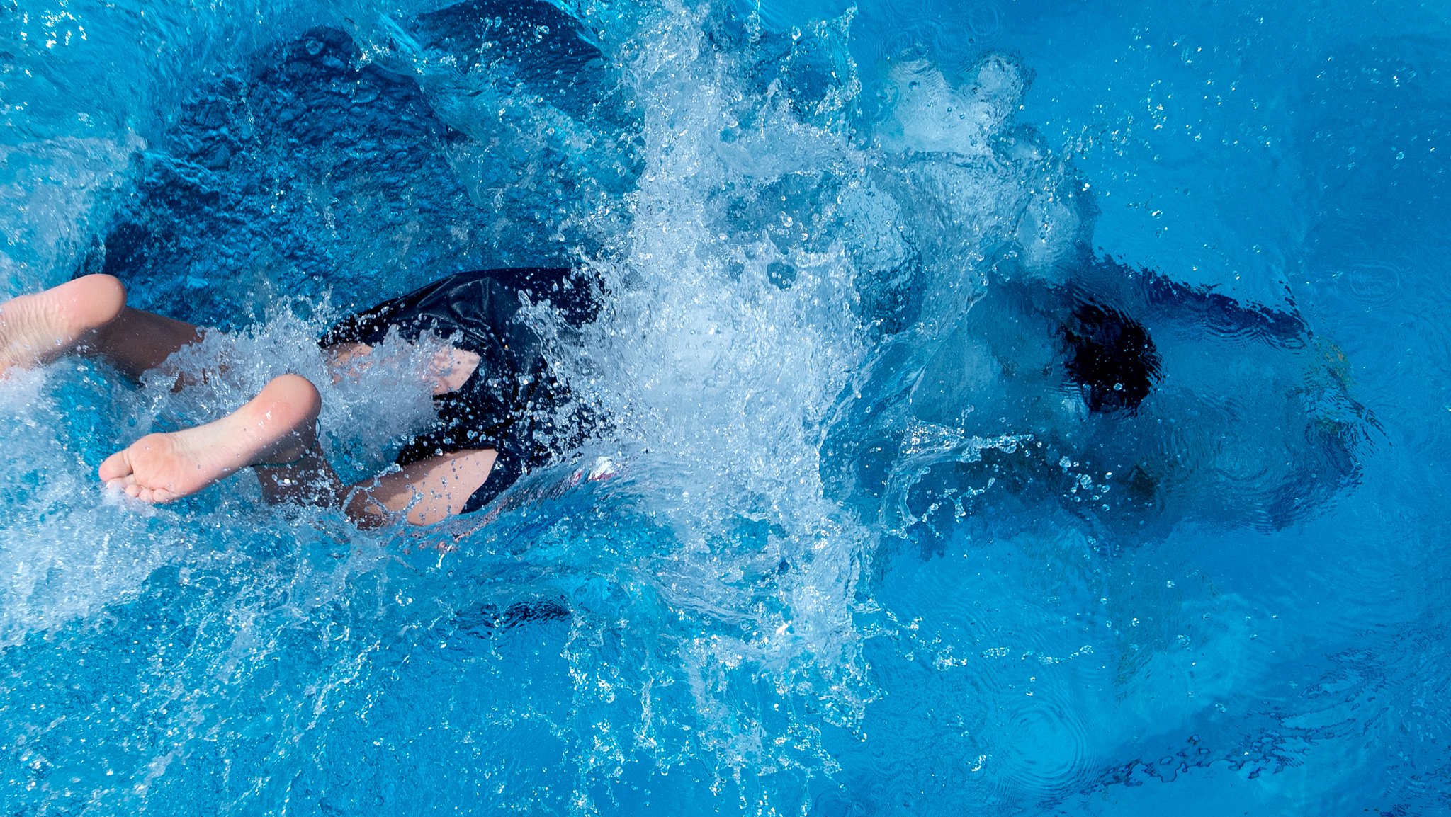 Jemand taucht im Freibad ab