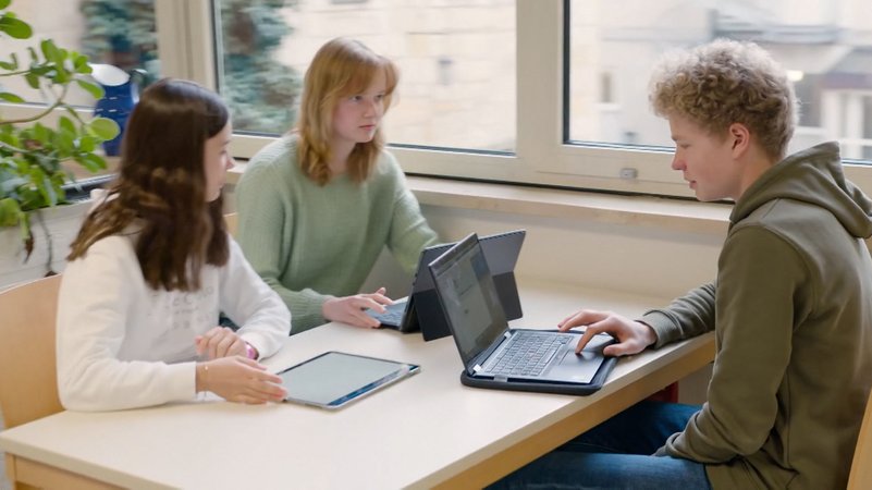 Schüler arbeiten gemeinsam an Laptops