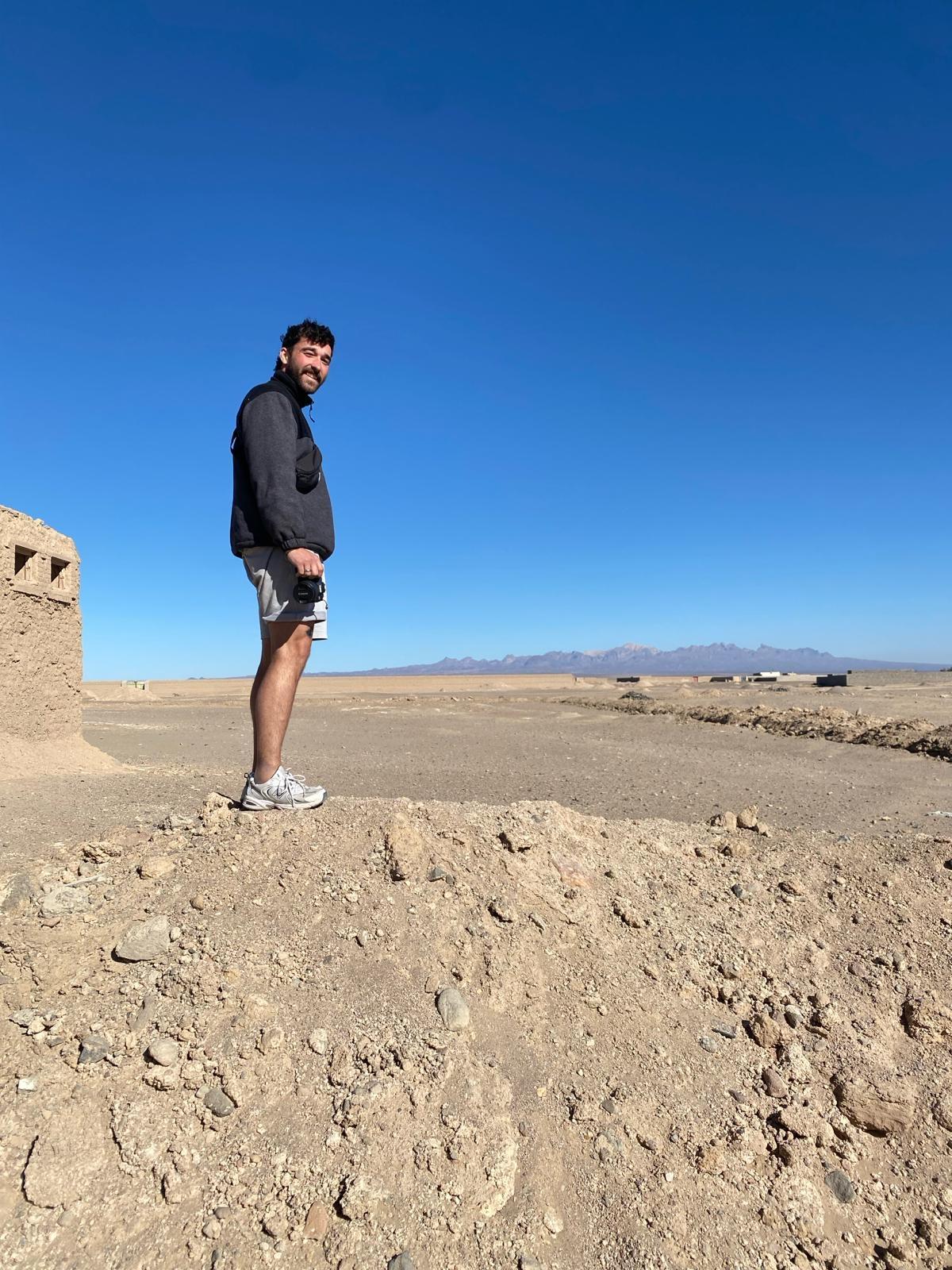 Valentin Oeckl steht mit einer Kamera in einer ländlichen Gegend von Pakistan.