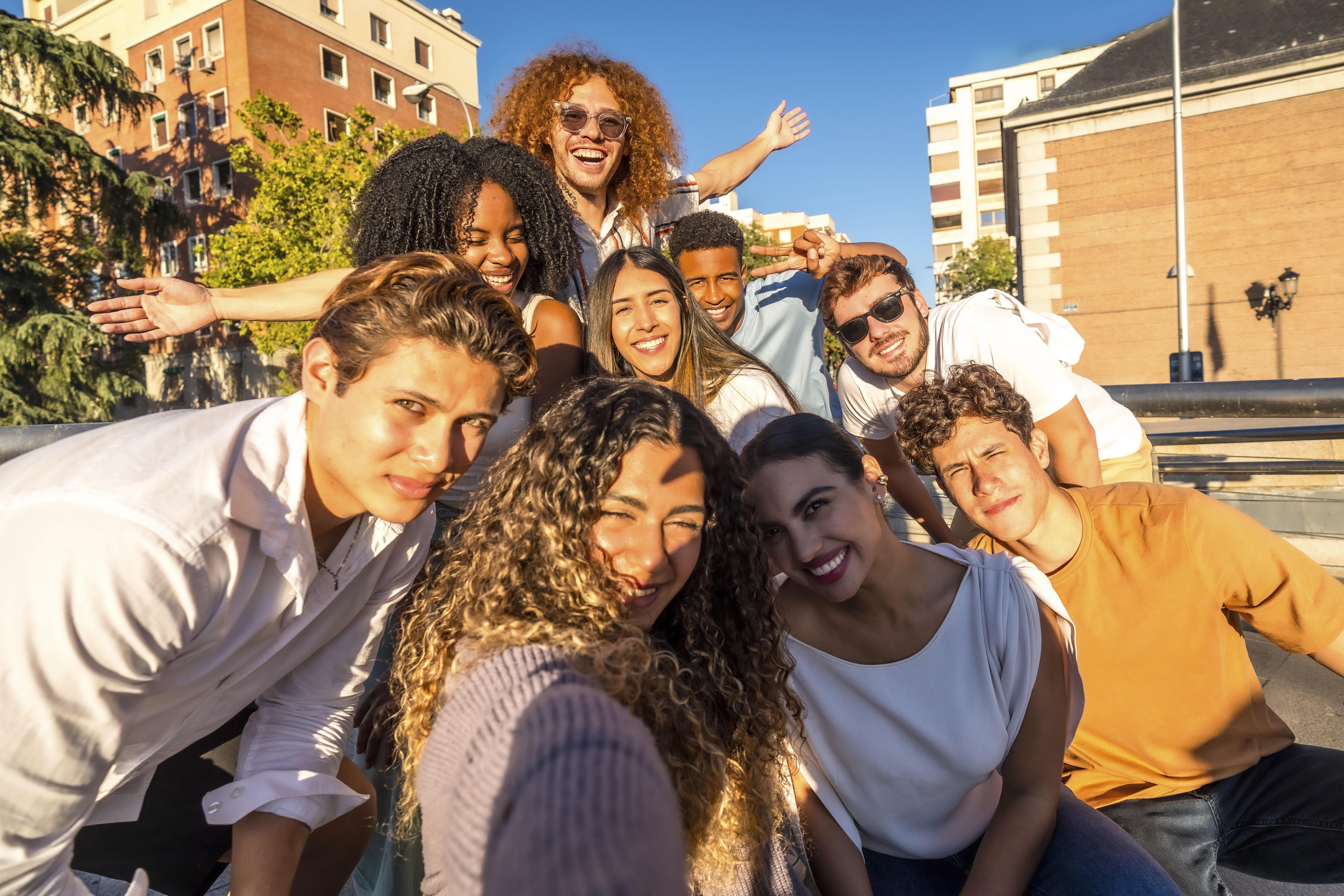 Frontalansicht einer multiethischen fröhlichen Freundesgruppe. Sie nehmen ein Selfie zusammen in der Stadt auf.