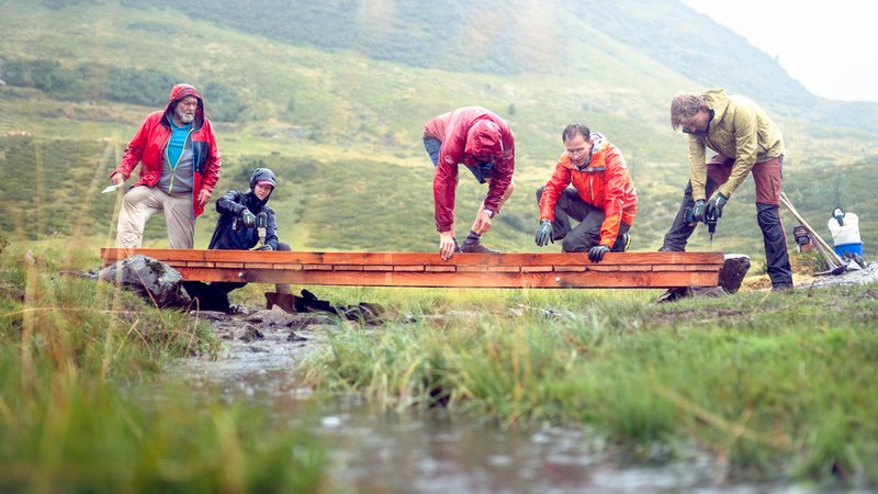 Fünf Freiwillige befestigen eine Metallbrücke in der Nähe der Zollnersee-Hütte in Kärnten. | Bild: ÖAV / Neuner-Knabl Fünf Freiwillige befestigen eine Metallbrücke in der Nähe der Zollnersee-Hütte in Kärnten.