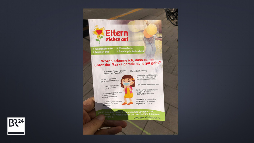 Ein Flyer der Initiative #Elternstehenauf wird in München verteilt.
