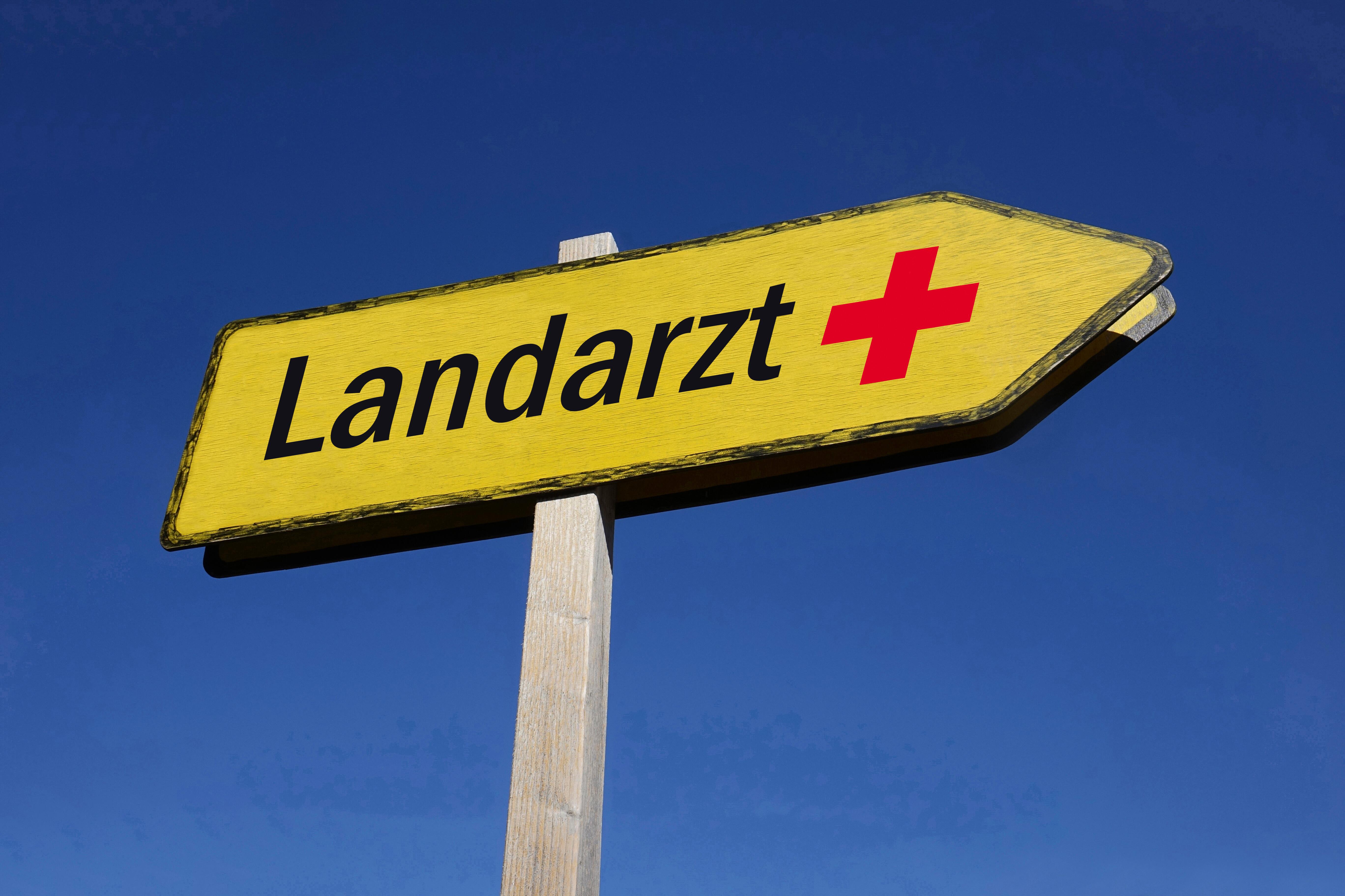 Ein Wegweiser zeigt die Richtung zu einem Landarzt an.