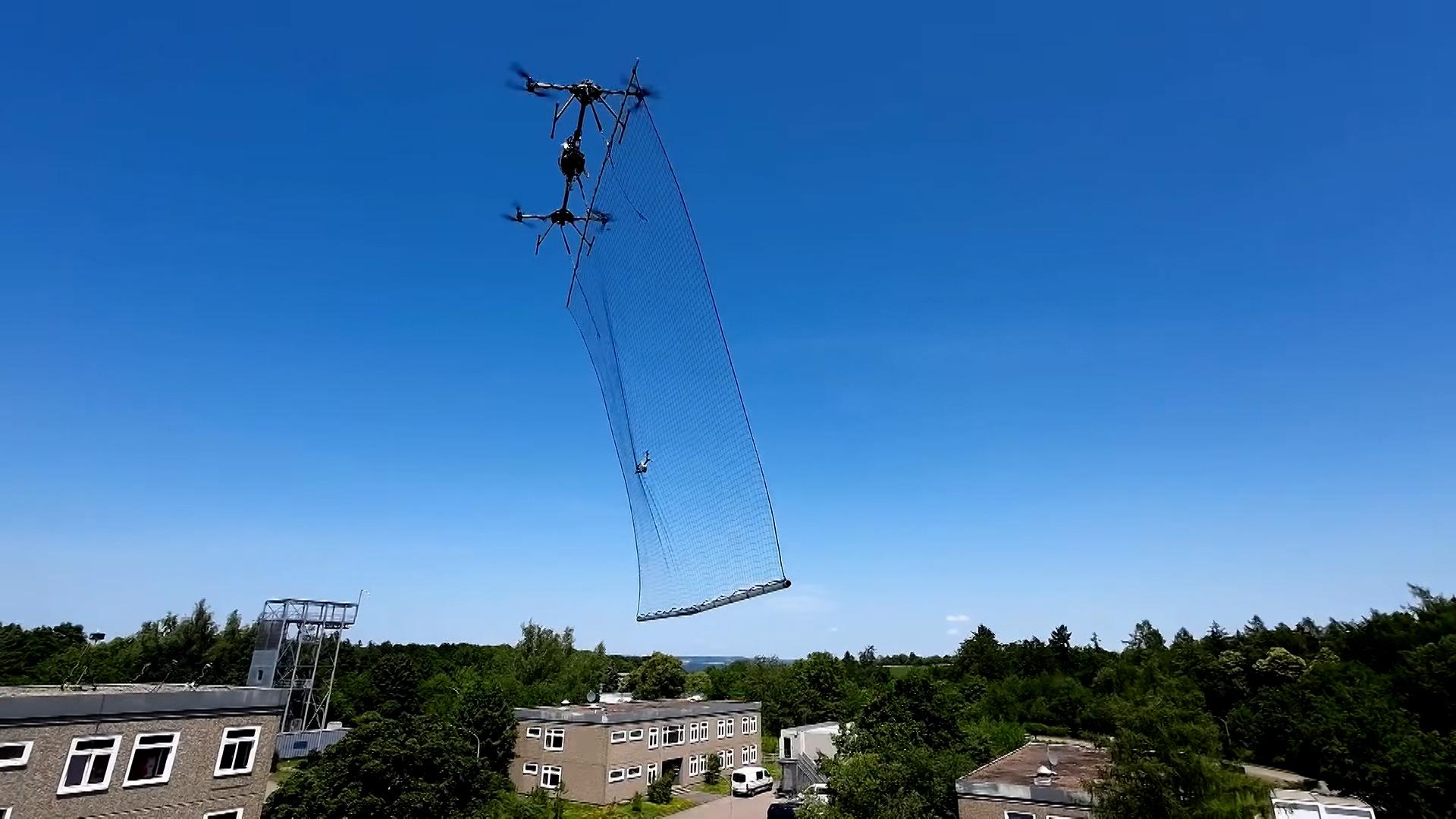 Die Würzburger Abwehrdrohne fliegt über eine kleinere Drohne und fängt sie mit einem großen Netz ein.