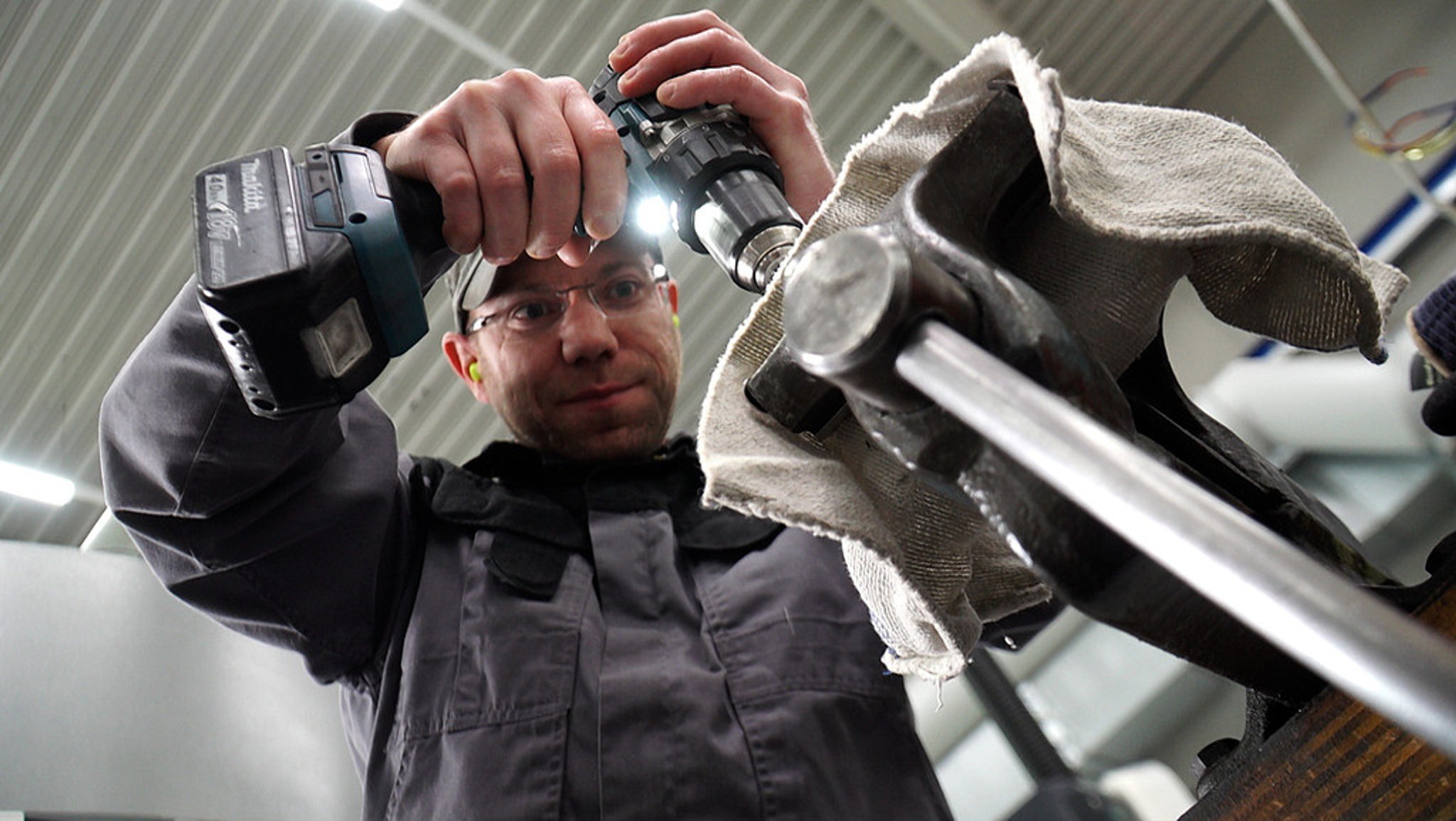 Arbeiter bohrt mit Bohrmaschine in der Firma Ortmeier.