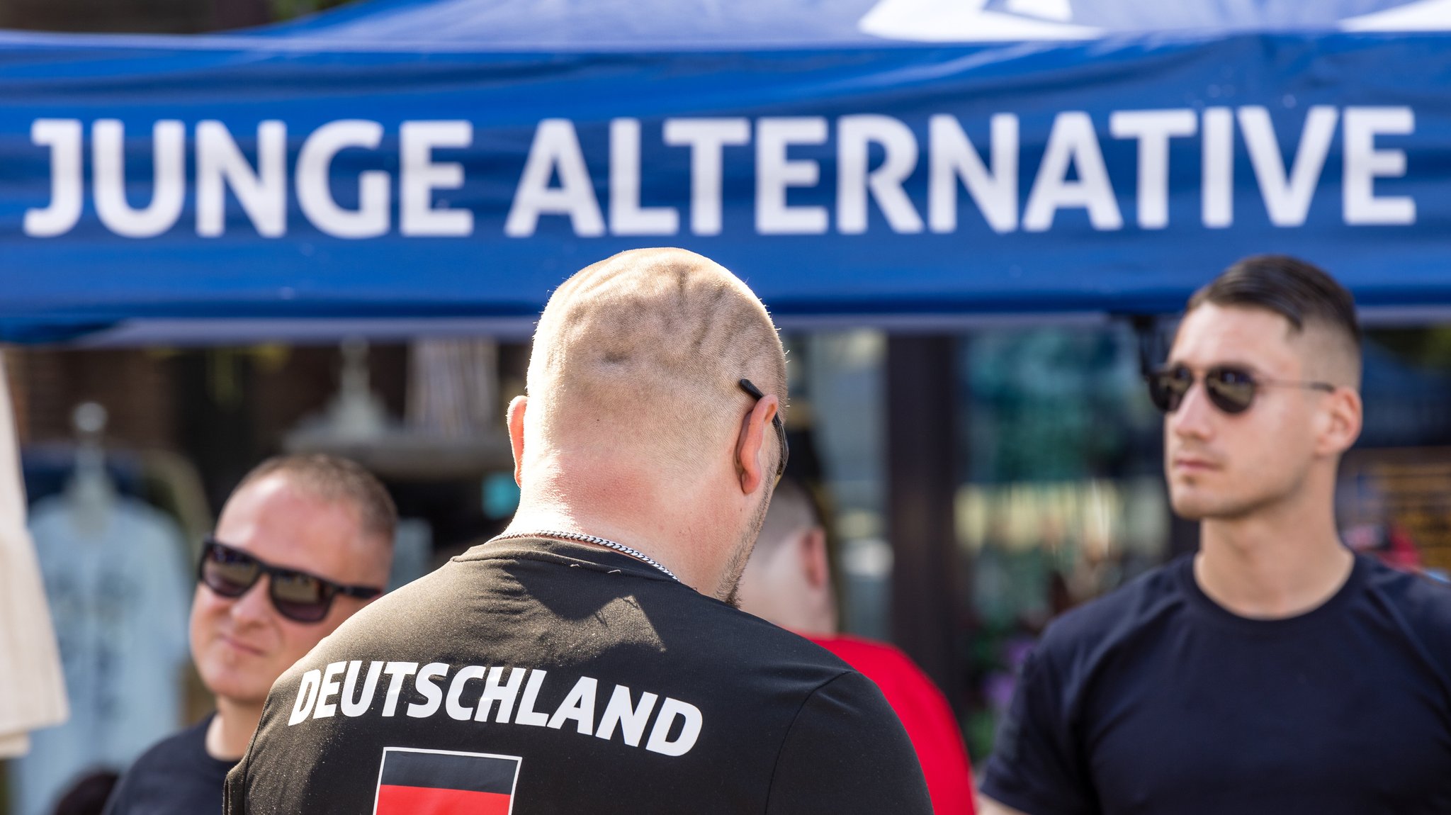 Ein Mann steht am 3. August 2024 bei einer Wahlkampfveranstaltung der AfD Brandenburg in Cottbus am Stand der Jungen Alternative, der Nachwuchsorganisation der AfD.