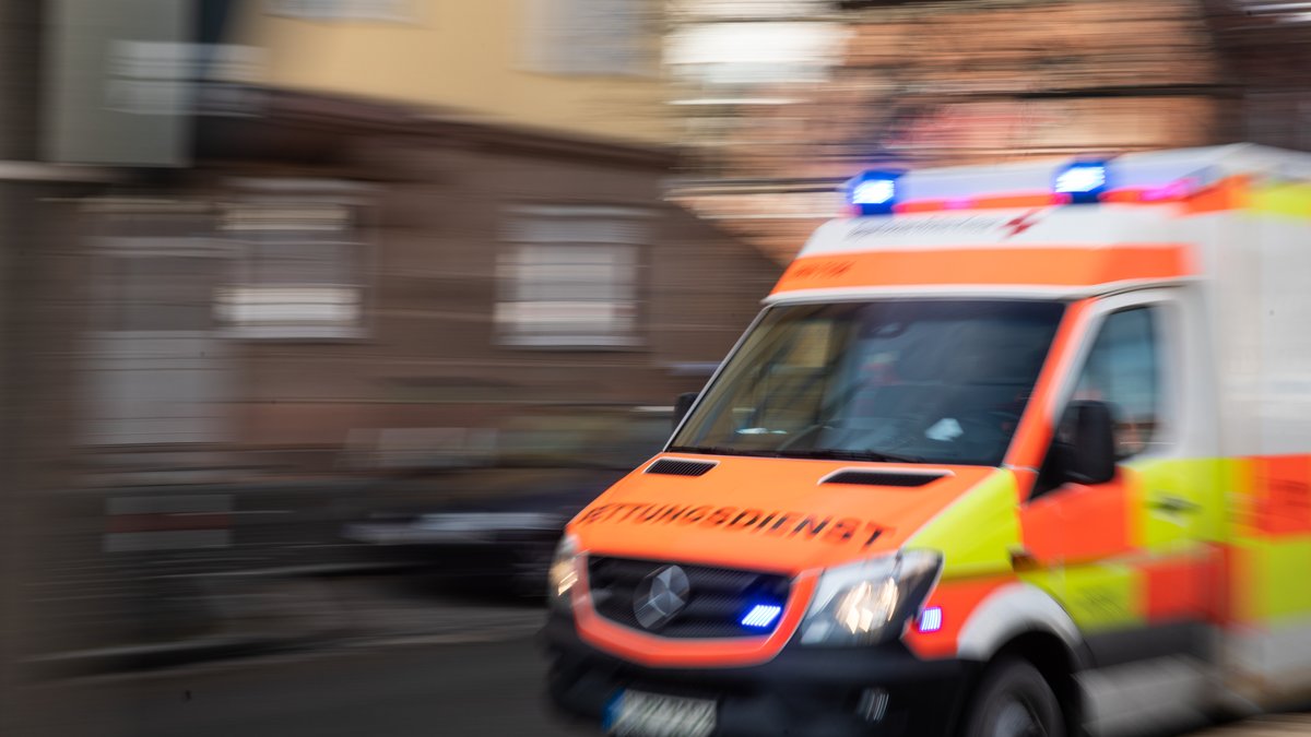 Verwischtes Bild eines Rettungswagens mit Blaulicht auf dem Weg zum Einsatz.