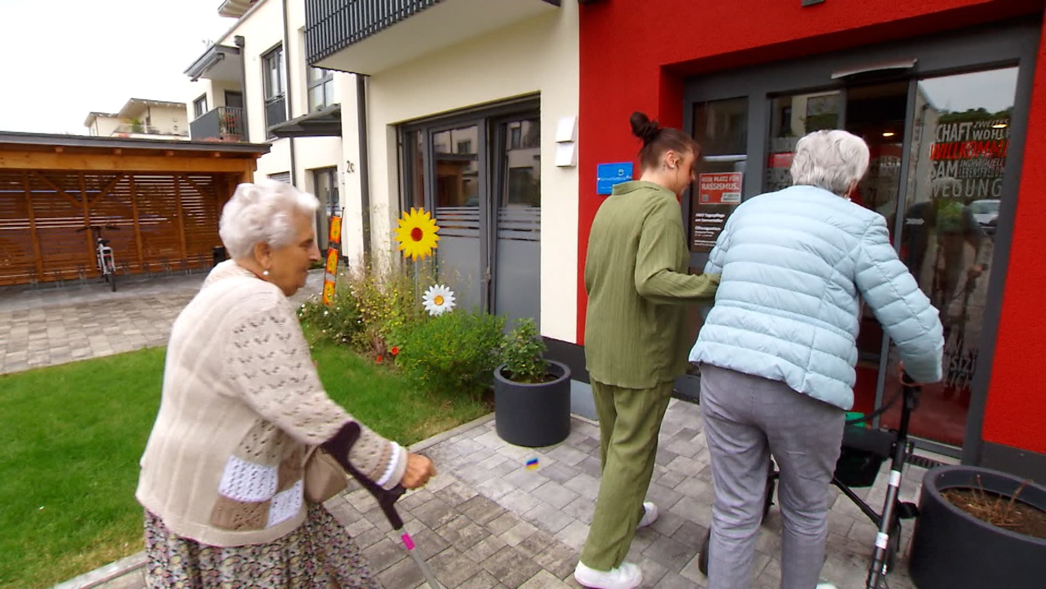 Junger Mann unterstützt zwei Seniorinnen