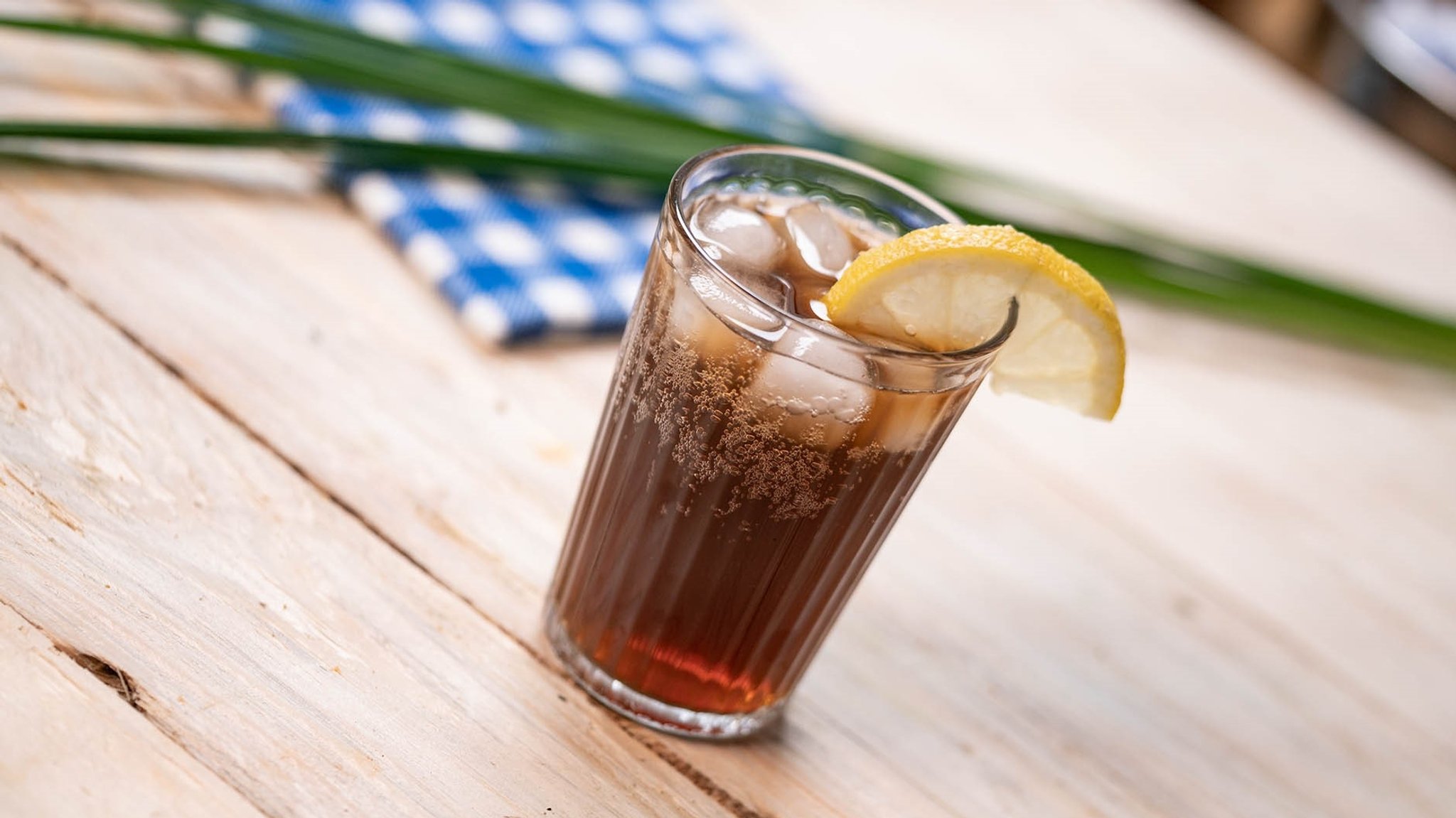 Ein Glas Cola-Mix-Getränk auf einem Holztisch