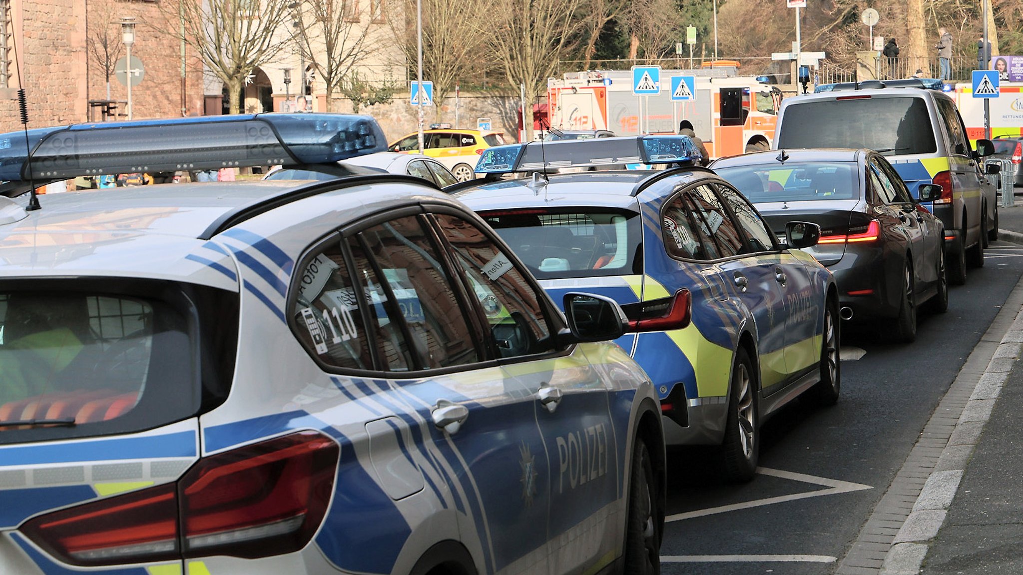 Einige Polizeifahrzeuge und Rettungswagen stehen in der Nähe eines Tatortes in Aschaffenburg