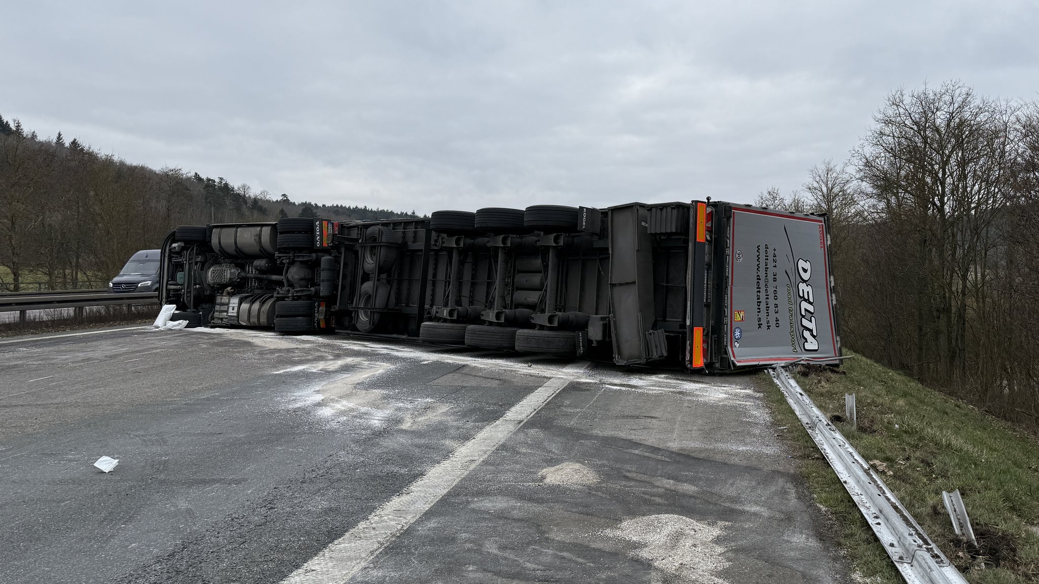 Ein Lastwagen liegt umgekippt auf der Autobahn und blockiert alle drei Fahrbahnen.