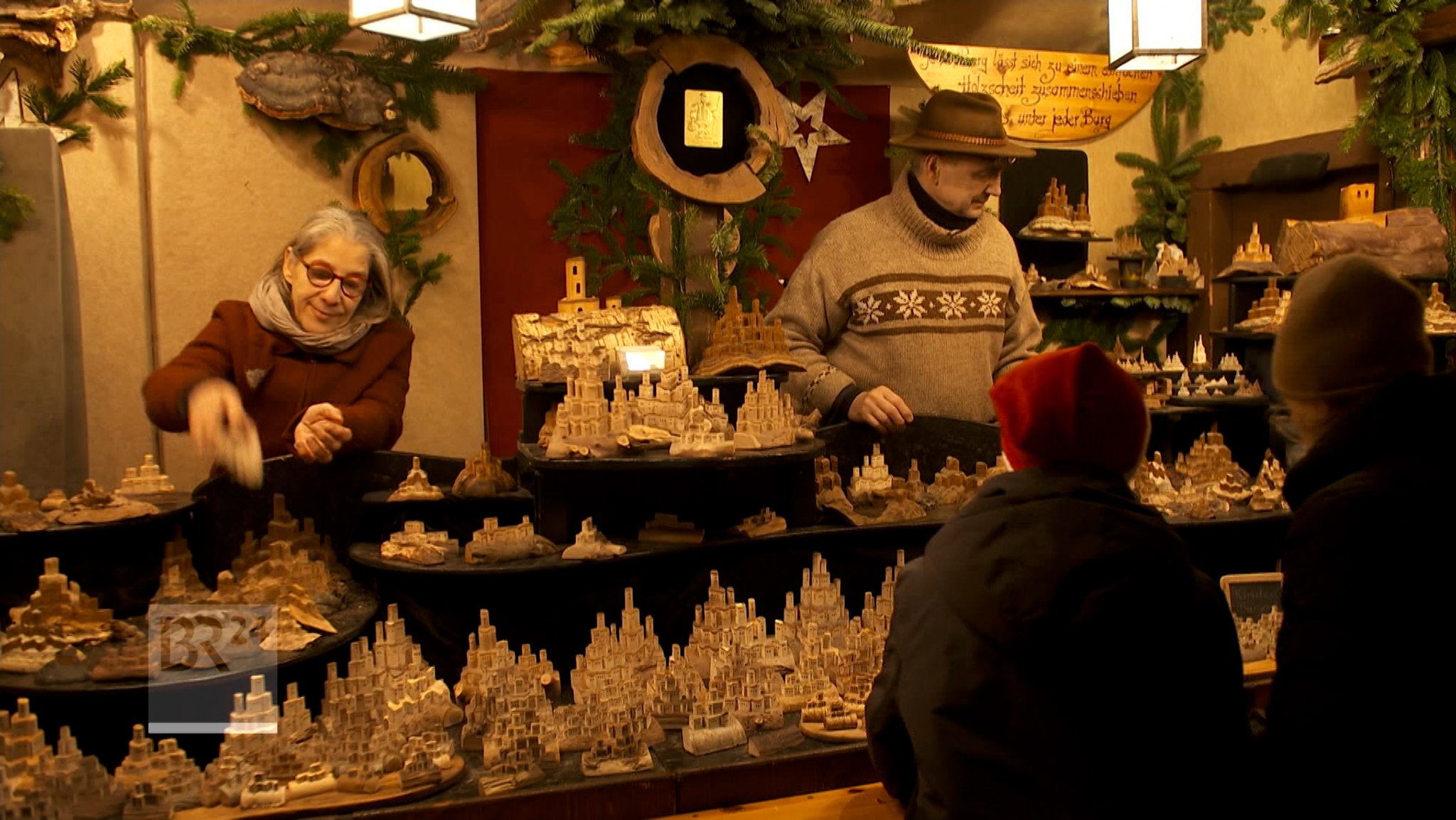 Zwei Personen stehen in einem Stand des Nürnberg Christkindlesmarktes.