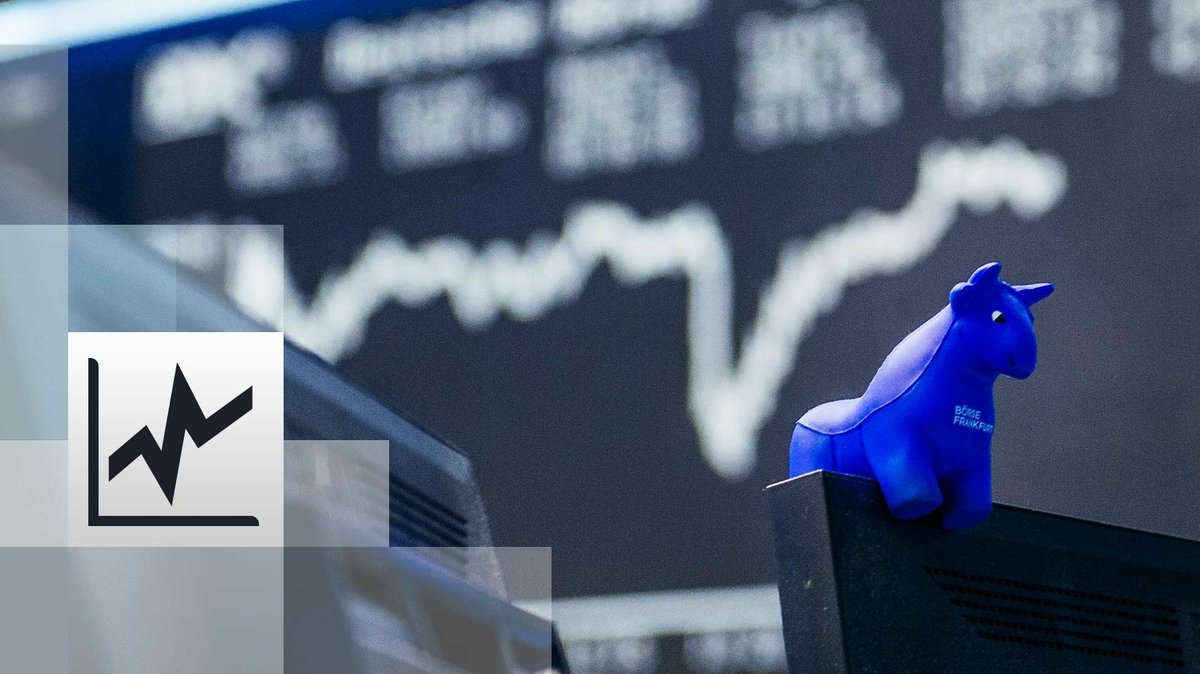 Ein blauer Stier aus Gummi sitzt auf der oberen Kante eines Bildschirmes, im Hintergrund die Kurstafel der Börse.
