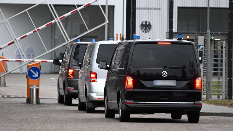 Drei Fahrzeuge der Polizei fahren auf das Gelände des Bundesgerichtshofes. Dort soll ein mutmaßlicher Reichsbürger  vorgeführt werden.