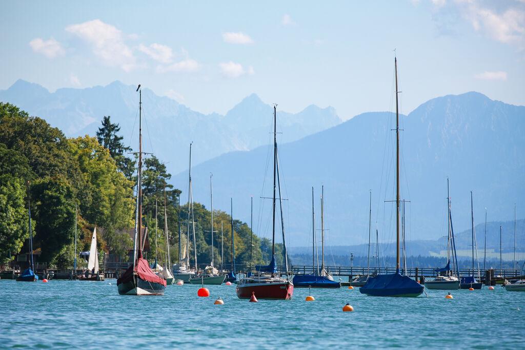 Segelboote am Starnberger See mit den bayerischen Alpen im Hintergrund.