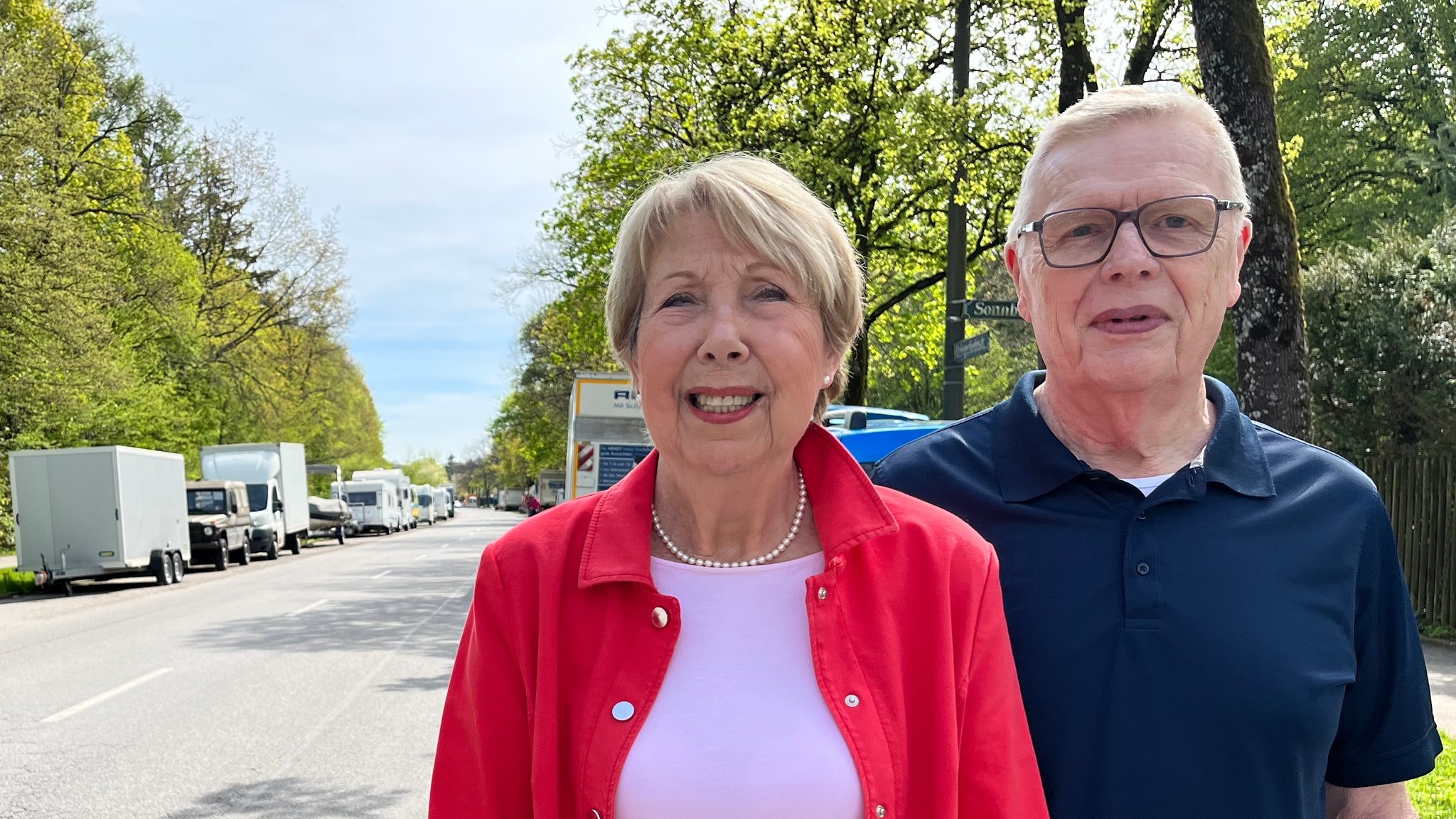 Ulla und Uli Haurand auf ihrer Straße am Münchner Waldfriedhof. Der  Seitenstreifen ist fast komplett mit Wohnmobilen und Anhängern zugestellt. 