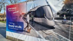 Eine Plakatwand zeigt wie die geplante Stadtbahn Regensburg aussehen könnte.  | Bild:BR/Marcel Kehrer