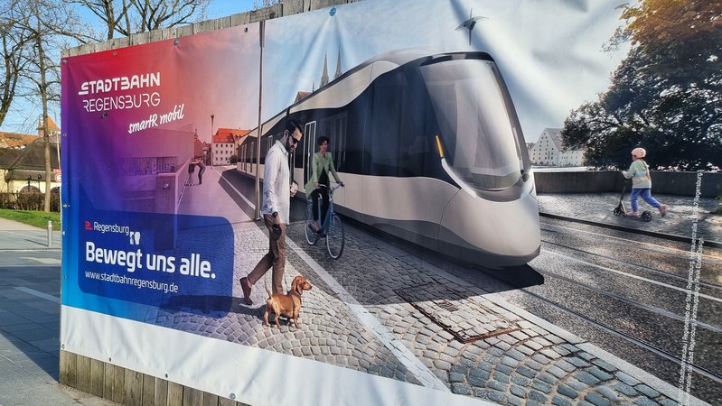 Eine Plakatwand zeigt wie die geplante Stadtbahn Regensburg aussehen könnte. | Bild: BR/Marcel Kehrer Eine Plakatwand zeigt wie die geplante Stadtbahn Regensburg aussehen könnte.