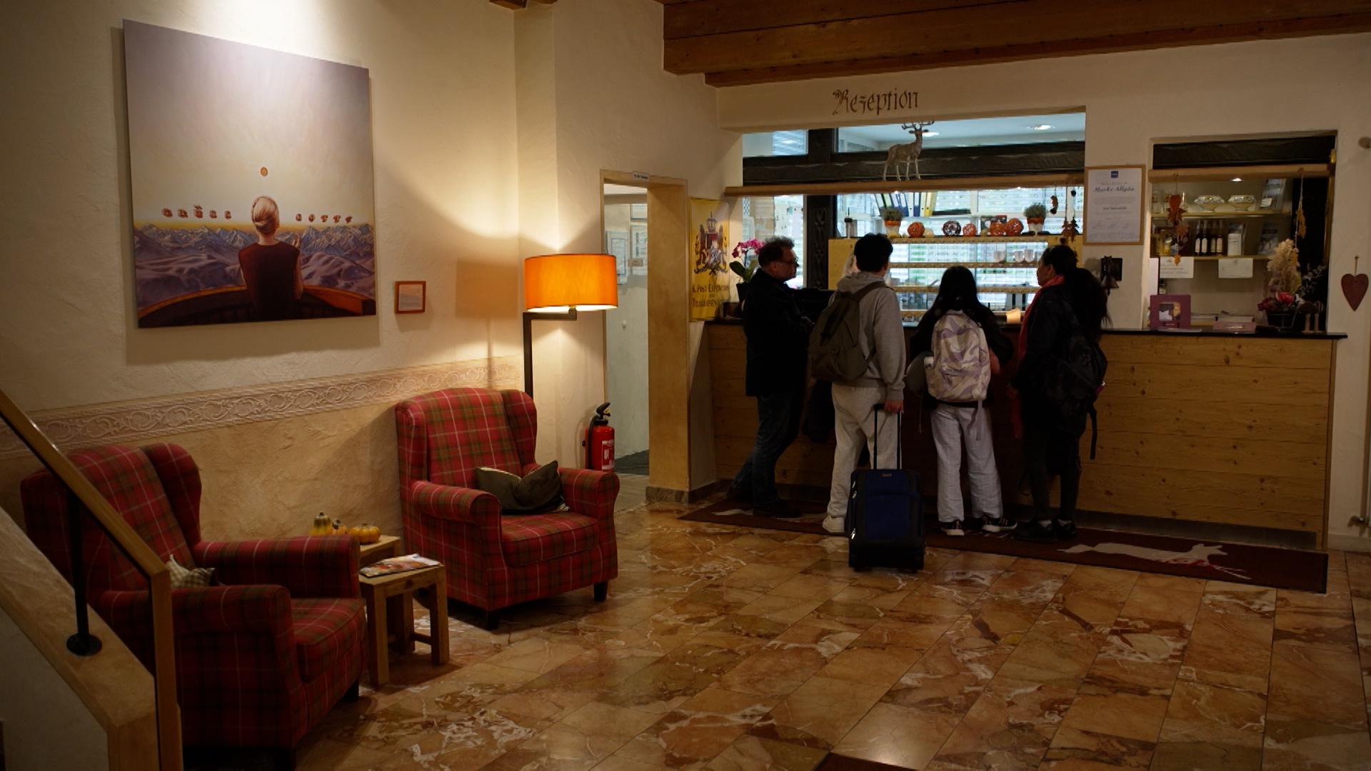 Eine Hotelrezeption mit Kunden und Kundinnen.