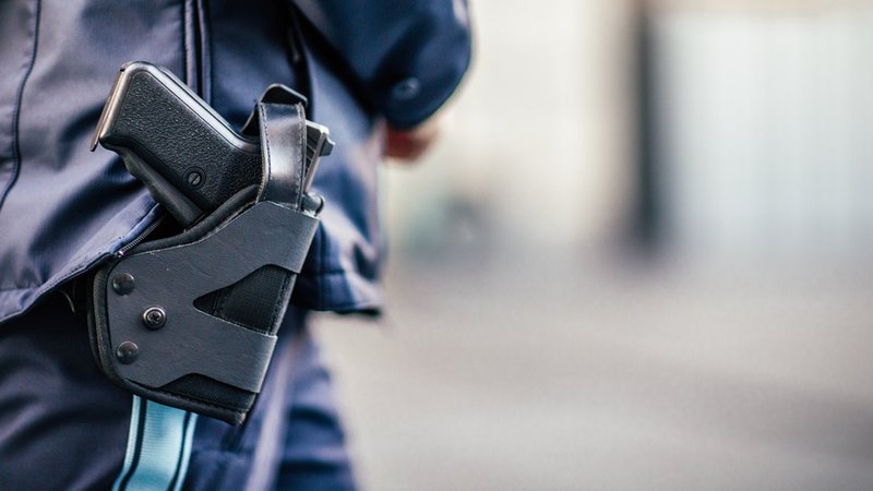 Am Einsatzgürtel einer Polizistin der Münchner Polizei hängt ein Holster mit eine Waffe.