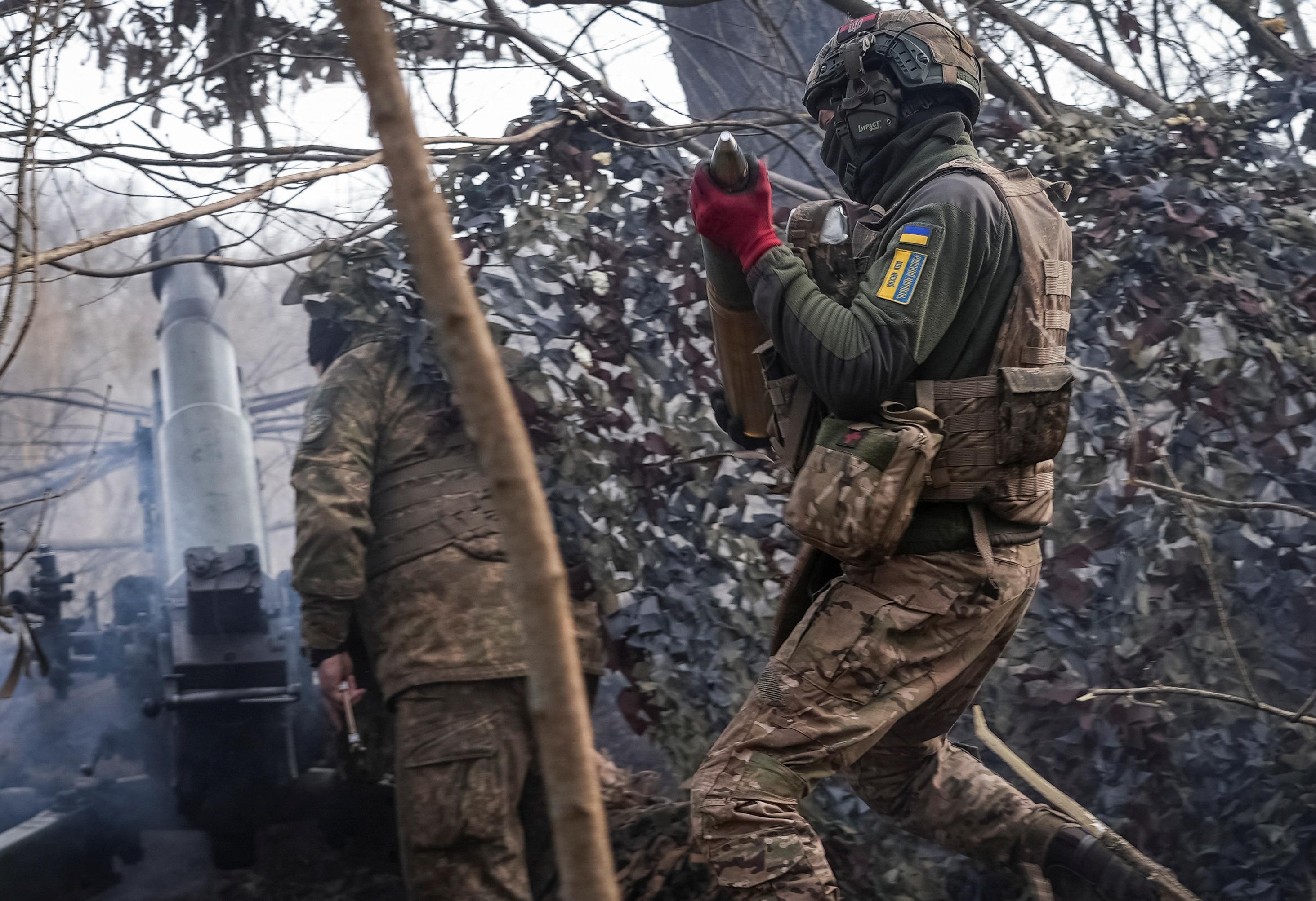 Ein ukrainischer Soldat trägt nahe der Front ein Artilleriegeschoss.