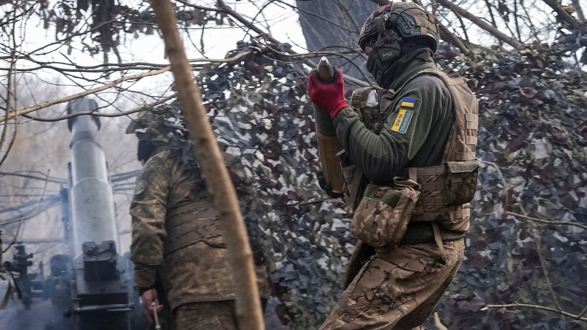 Ein ukrainischer Soldat trägt nahe der Front ein Artilleriegeschoss.