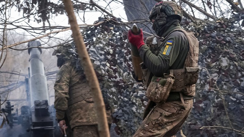 Ein ukrainischer Soldat trägt nahe der Front ein Artilleriegeschoss.