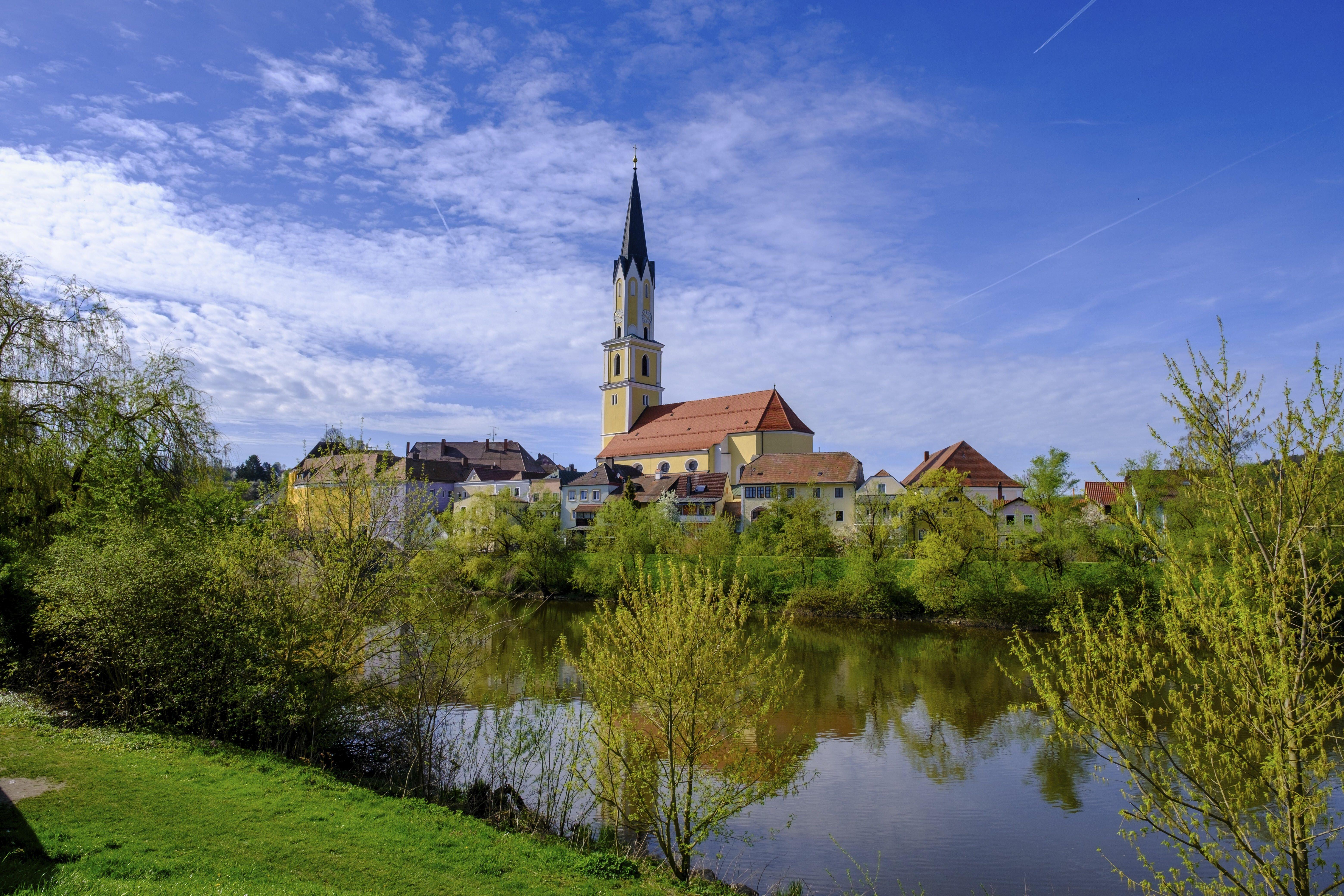 Stadtansicht von Vilshofen und der Kirche St. Johannes der Täufer, davor die Vils, im Frühling.