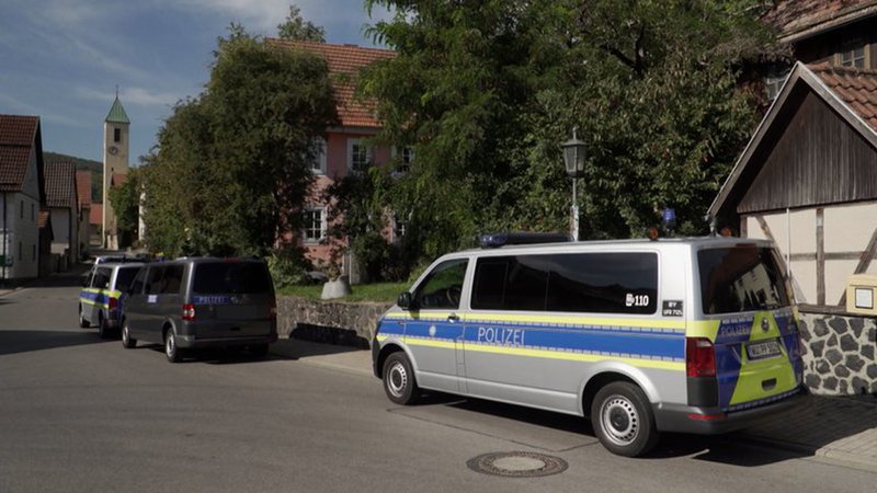 Die Polizei hat heute Razzien bei der Vereinigung "Die Artgemeinschaft" durchgeführt, wie hier in der Rhön in Unterfranken. Vor einem Anwesen stehen mehrere Polizei-Fahrzeuge.