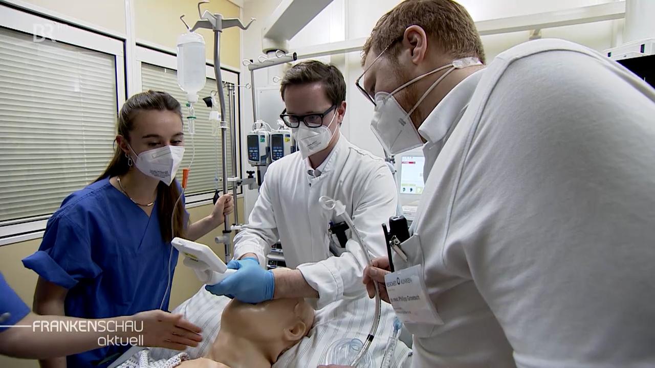 Studenten üben an einer Puppe.