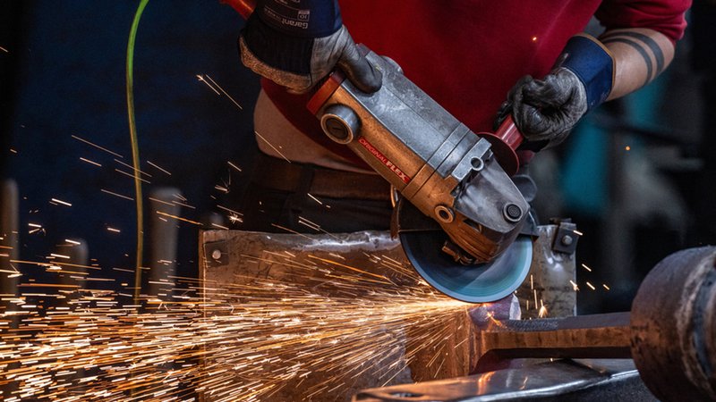 Ein Mann bearbeitet mit einem Winkelschleifer einen Glockenklöppel. | Bild: dpa-Bildfunk/Armin Weigel Ein Mann bearbeitet mit einem Winkelschleifer einen Glockenklöppel.