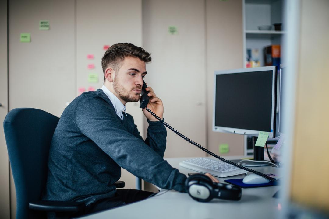 Ein Mitarbeiter telefoniert am Arbeitsplatz.