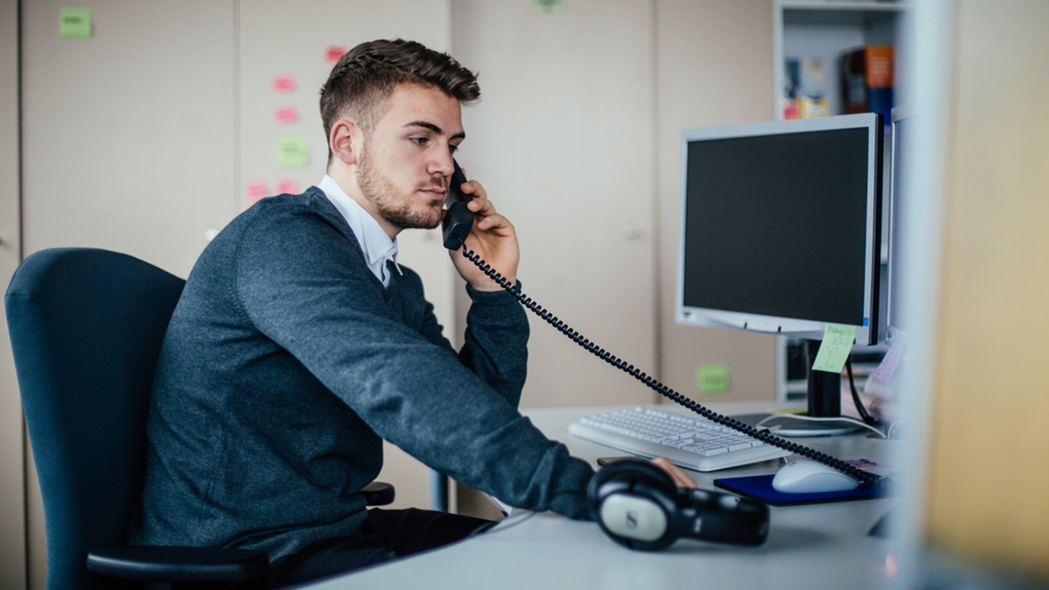 Ein Mitarbeiter telefoniert am Arbeitsplatz.