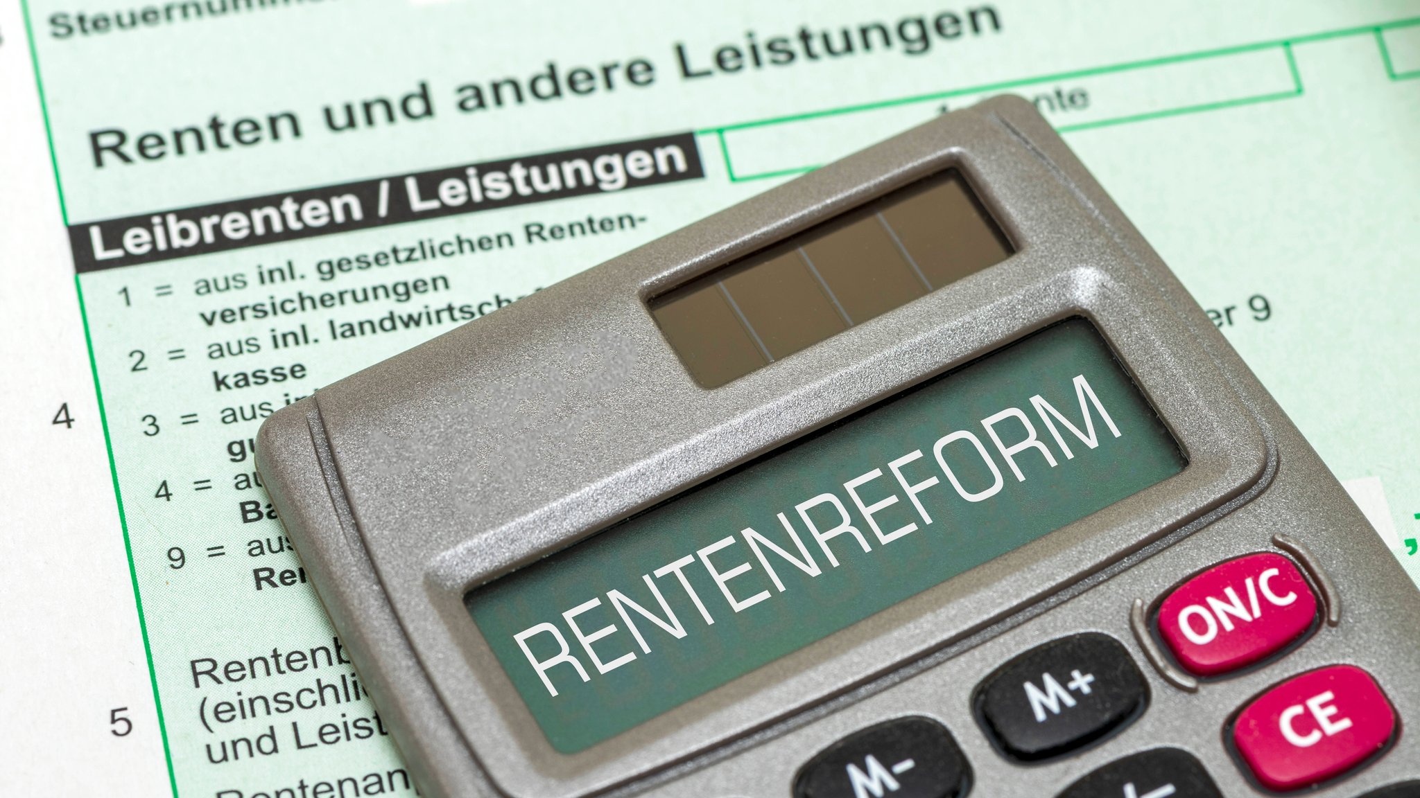 Auf dem Display von einem Taschenrechner steht das Wort Rentenreform über einem Formular für die Steuererklärung | Bild: picture alliance / SZ Photo | Wolfgang Filser Auf dem Display von einem Taschenrechner steht das Wort Rentenreform über einem Formular für die Steuererklärung