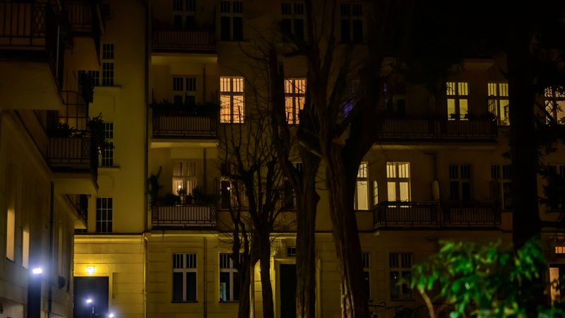 Blick auf das Hintergebäude einer Wohnanlage entlang eines beleuchteten Weges bei Nacht | Bild: stock.adobe.com/Mickis Fotowelt Blick auf das Hintergebäude einer Wohnanlage entlang eines beleuchteten Weges bei Nacht