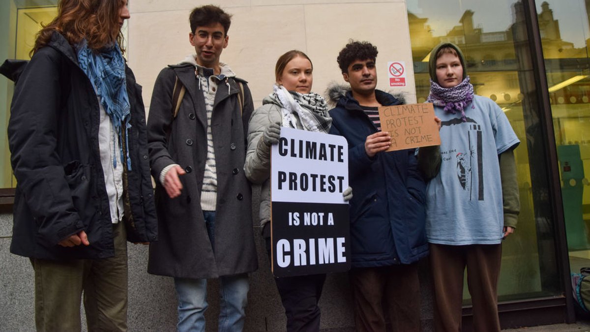 Mit einem Schild weist Greta Thunberg darauf hin, dass Klimaprotest keine Straftat sei