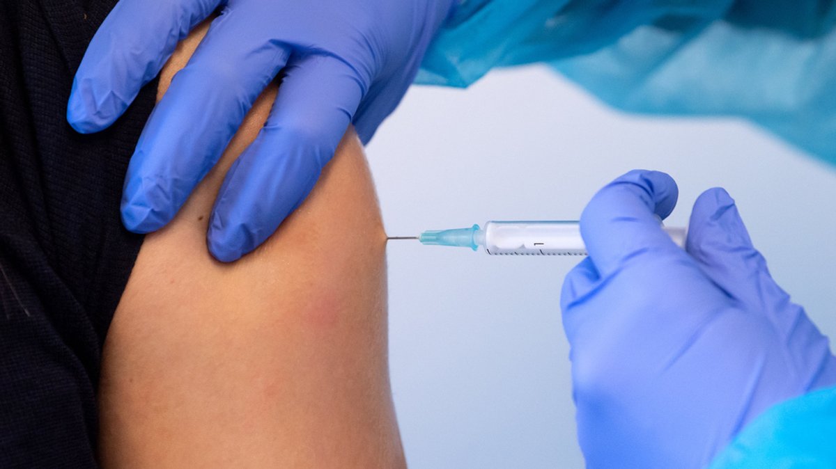 Eine Frau lässt sich gegen Civid-19 impfen.