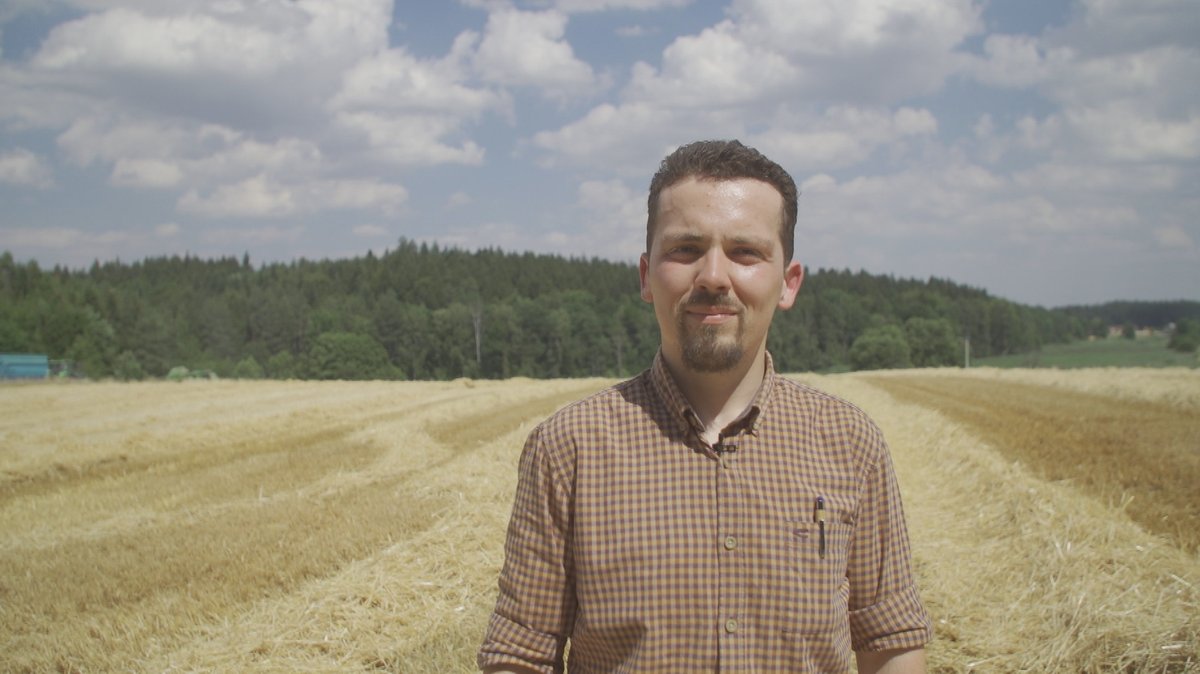 Zu sehen ist der Landwirt Marco Hüttner vor seinem Weizenfeld.