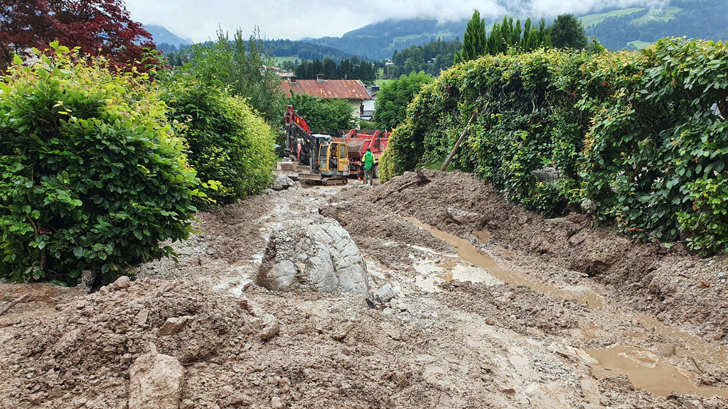 Schutt und Schlamm bedecken eine Straße im Berchtesgadener Land nach dem Starkregen 2021. 