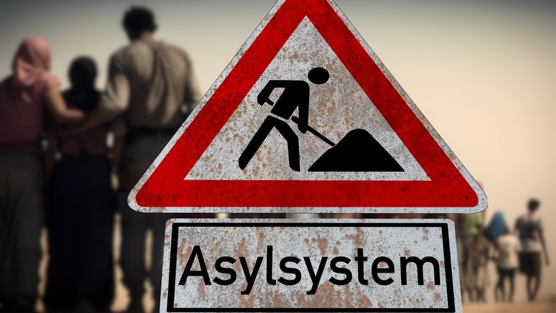 Ein Baustellensymbol mit der Aufschrift "Asylsystem" vor einer Familie.