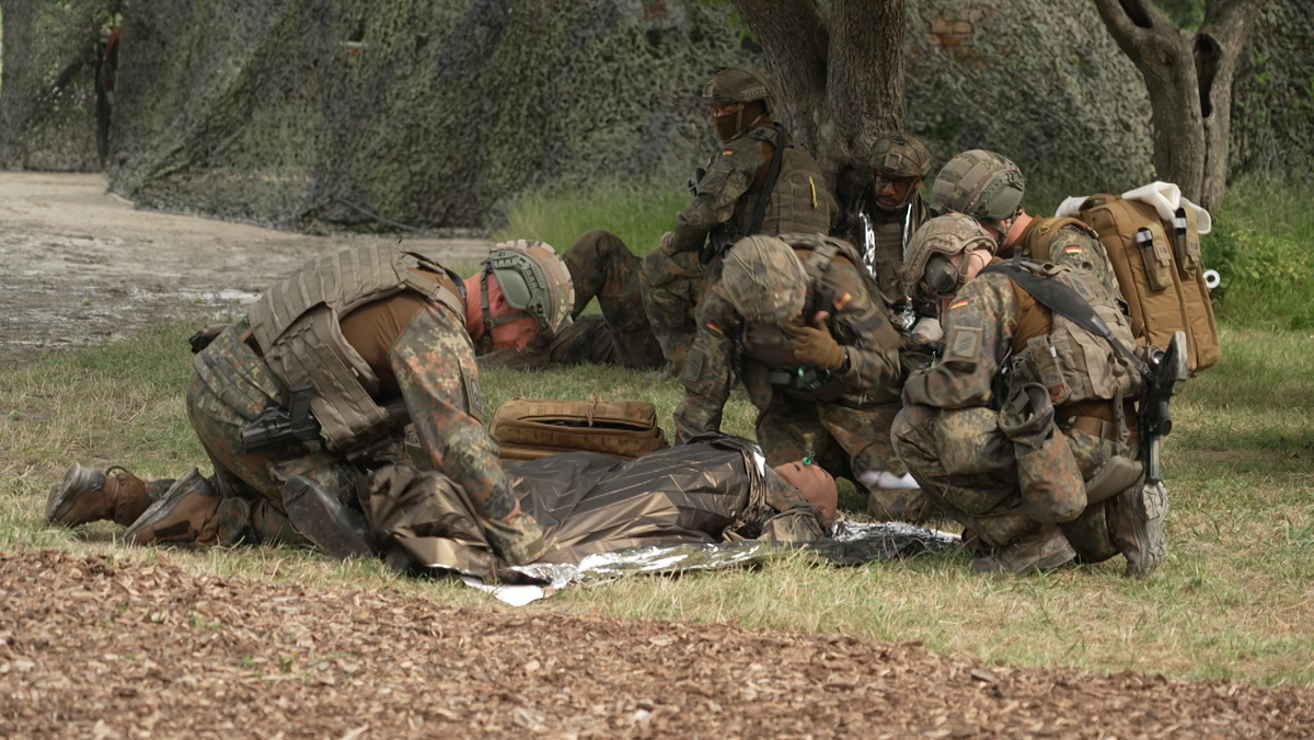 Soldaten versorgen bei einer Übung einen "verletzten" Dummy, der am Boden liegt. 