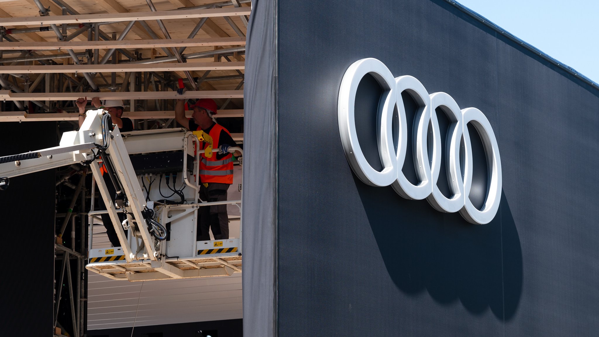 Arbeiter bauen einen Stand von Audi auf einer Messe auf.
