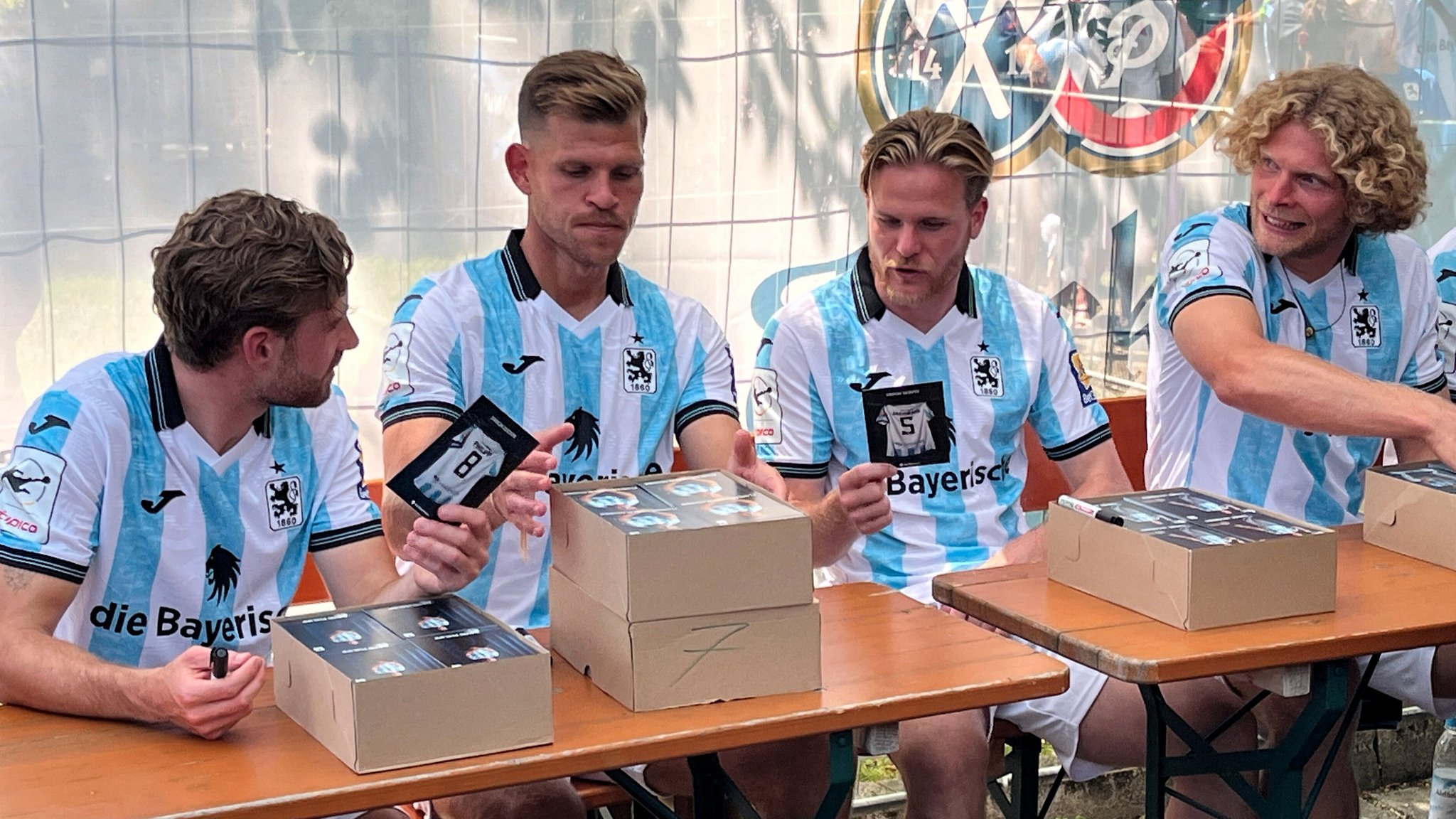 20.07.2025, Bayern, München: David Philipp, Florian Niederlechner, Thore Jacobsen und Jesper Verlaat (l-r), Spieler des TSV 1860 München schreiben beim Fanfest Autogramme. Foto: Christian Kunz/dpa +++ dpa-Bildfunk +++